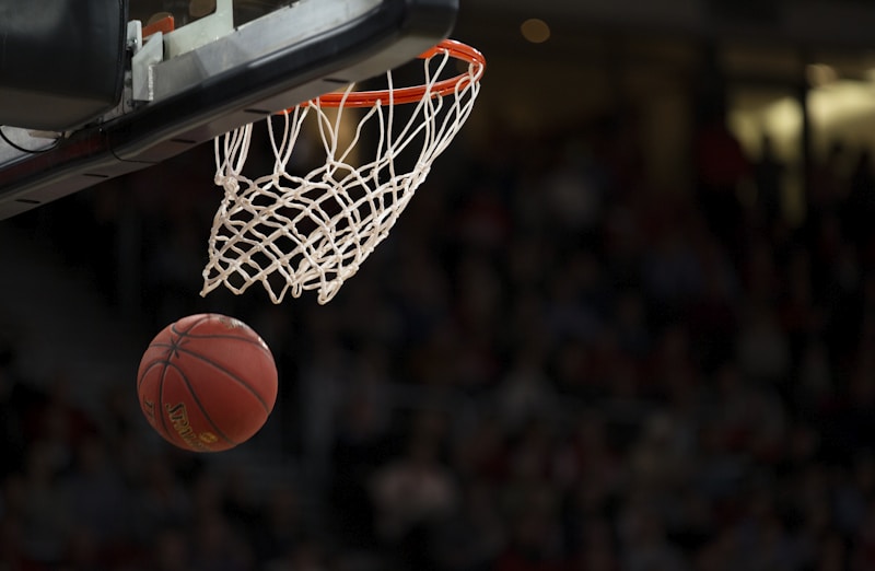 Basketball player shooting a three-pointer in a packed stadium